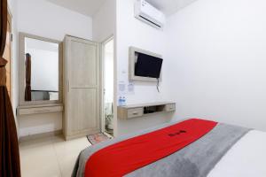 a bedroom with a bed and a tv on the wall at RedDoorz Premium @ Ampera Raya 2 in Jakarta +25 photos