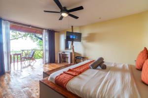 a bedroom with a bed with a ceiling fan at Nakabalo Guesthouse & Restaurant in Siquijor