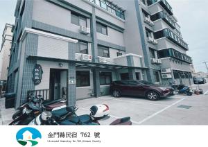 a building with motorcycles parked in a parking lot at 瑪麗殿民宿 in Jinning