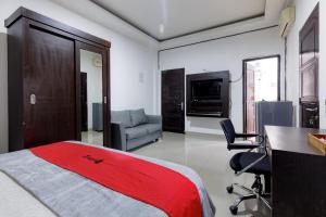 a bedroom with a bed and a desk and a chair at RedDoorz Premium @ Ampera Raya 2 in Jakarta