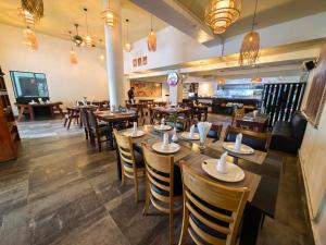 a dining room with wooden tables and chairs at Invito Guesthouse in Sihanoukville