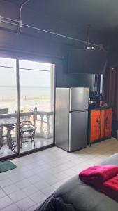 a kitchen with a refrigerator and a table with a view at HiSSS Style ชะอำ in Cha Am