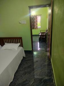 a room with a bedroom with a bed and a piano at Manjunatha nilaya sute delux ordinary room in Kollūru