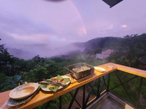 a table with a plate of food on top of a mountain at Coffee Myhome in Xuan An