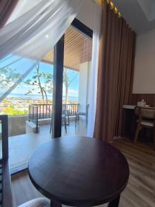 a dining room with a table and a view of the ocean at Wisma SIDAPORE JD in Lamobuang