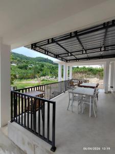 a patio with tables and chairs on a balcony at Wisma SIDAPORE JD in Lamobuang