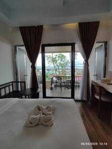 a bedroom with a bed with a bow on it at Wisma SIDAPORE JD in Lamobuang