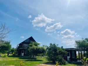 a house in the middle of a field with trees at Relax Cottage in Mailagamuwa