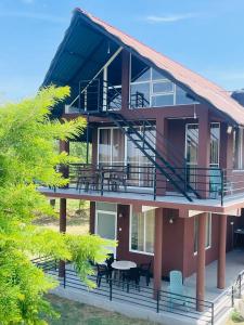 a house with a deck with tables and chairs at Relax Cottage in Mailagamuwa
