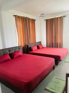 two beds with red covers in a room at Relax Cottage in Mailagamuwa +21 photos