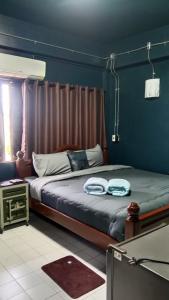 two beds in a room with blue walls at HiSSS Style ชะอำ in Cha Am