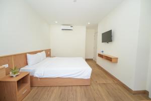 a bedroom with a bed and a tv on a wall at King Hotel in Quy Nhon