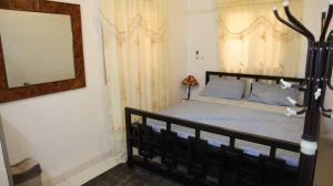 a bedroom with a black bed and a mirror at AMAL HoME in Ouagadougou