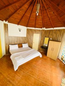 a bedroom with a large bed and a wooden ceiling at The Hidden Cove in Bhīm Tāl