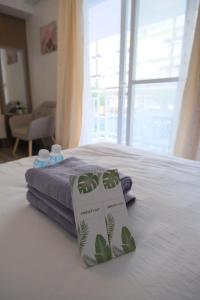 a hotel room with a bed with a book on it at Airport Gem with Pool and Gym in Pusok +23 photos