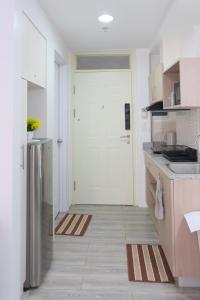 a kitchen with a white door and a refrigerator at Airport Gem with Pool and Gym in Pusok