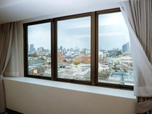 a window with a view of a city at The Wang Yaowarat Hotel in Bangkok
