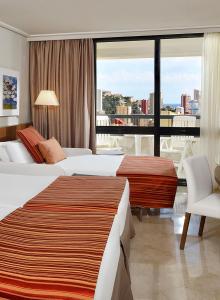 a hotel room with two beds and a large window at Meliá Benidorm in Benidorm