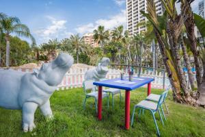 two statues of dogs sitting around a blue table at Meliá Benidorm in Benidorm