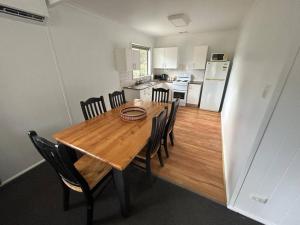 a kitchen and dining room with a wooden table and chairs at Comara Jindabyne Unit 1 in Jindabyne