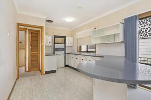 a kitchen with white cabinets and a table in it at Cheerful Beach house at Redhead - BBQ, Beach, Views in Redhead +9 photos