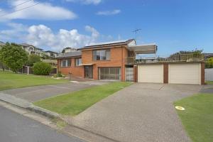 a brick house with a garage and a driveway at Cheerful Beach house at Redhead - BBQ, Beach, Views in Redhead