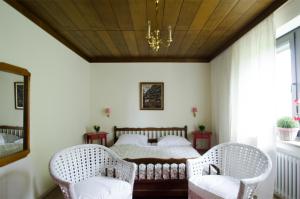 a bedroom with a bed and two chairs at Schwarzberghof in Dachau
