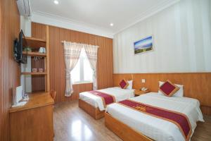 a hotel room with two beds and a window at King Hotel in Quy Nhon +76 photos
