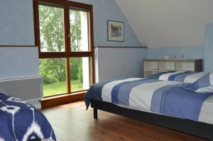 a bedroom with two beds and a window at La ferme d'aristide in Saillenard