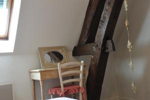 une table en bois avec un miroir et une chaise dans l'établissement La ferme d'aristide, à Saillenard