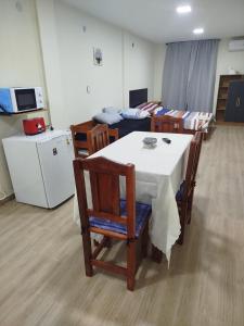 a room with a table and chairs and a kitchen at Departamento bonito con balcón in La Banda