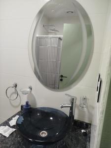 a bathroom with a black sink and a mirror at Departamento bonito con balcón in La Banda