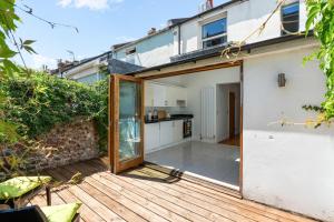 a sliding glass door leading to a kitchen on a deck at Leafy Haven By My Getaways in Brighton & Hove