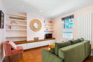 a living room with a green couch and a television at Leafy Haven By My Getaways in Brighton & Hove