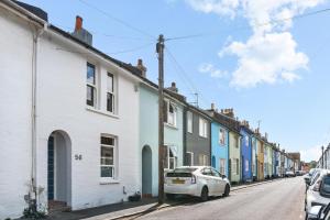 a white car parked in front of a row of houses at Leafy Haven By My Getaways in Brighton & Hove