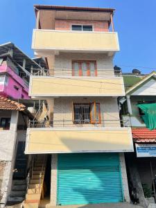 a building with two green garage doors in front of it at Instahomestay in Vālpārai