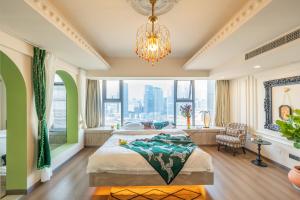a bedroom with a large bed and a chandelier at INVIS Urban High-rise Suites in Chengdu