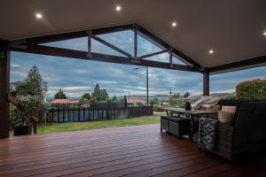 a screened in deck with a view of a yard at Clareview Cottage in Rotorua