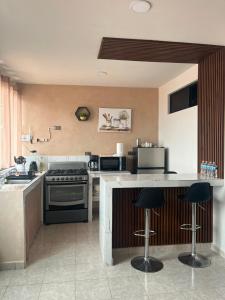 a kitchen with a stove and some bar stools at Departamento en el CENTRO DE XALAPA 2habitaciones GARAGE INCLUIDO in Xalapa +13 photos