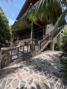 a house with a staircase leading to a patio at Secret Cottages Chaweng Noi in Koh Samui