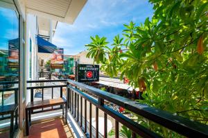 a balcony with a bench and trees on a street at Kata Station Boutique Hotel, Kata Beach in Kata Beach