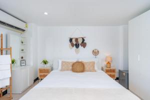 a bedroom with a large white bed and two tables at Kata Station Boutique Hotel, Kata Beach in Kata Beach