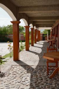 a row of tables and benches on a patio at Hotel del Pueblo in Teotitlán del Valle