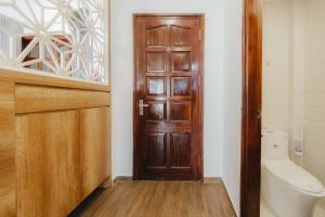 a bathroom with a wooden door and a toilet at BOHO Homestay No10 Alley 08 Ton That Thiep - Hanoi in Hanoi +31 photos