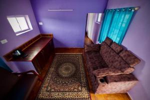 a purple living room with a couch and a rug at Shabeer's White Castle in Ooty