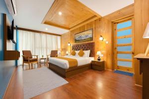a hotel room with a bed and a table and chairs at Hotel The Fortune Luxury Rooms Near Mall Road Manali By Vistas - Best Selling Centrally Heated Property 2025-26 in Manāli