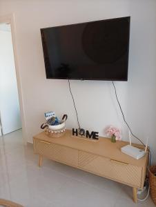 a flat screen tv on top of a wooden table at Appartement piscine Rosas in Roses