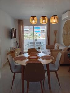 a living room with a table and chairs and a couch at Appartement piscine Rosas in Roses