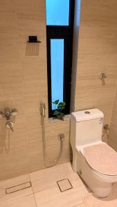 a bathroom with a toilet and a window at August in Jazan