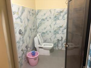 a bathroom with a toilet with a marble wall at Winter Valley Grand Araku in Araku